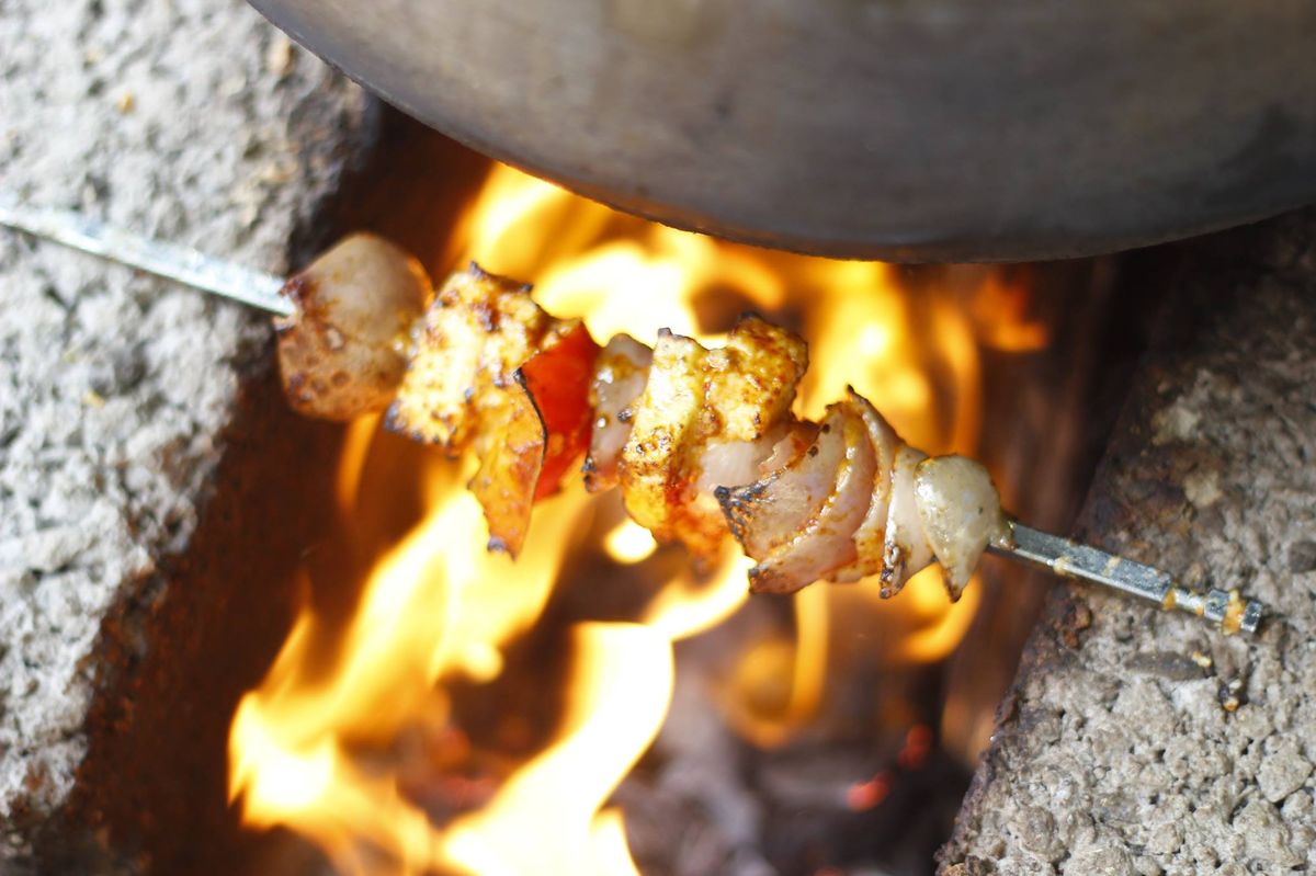 Skewered paneer tikka starter grilling over an open flame