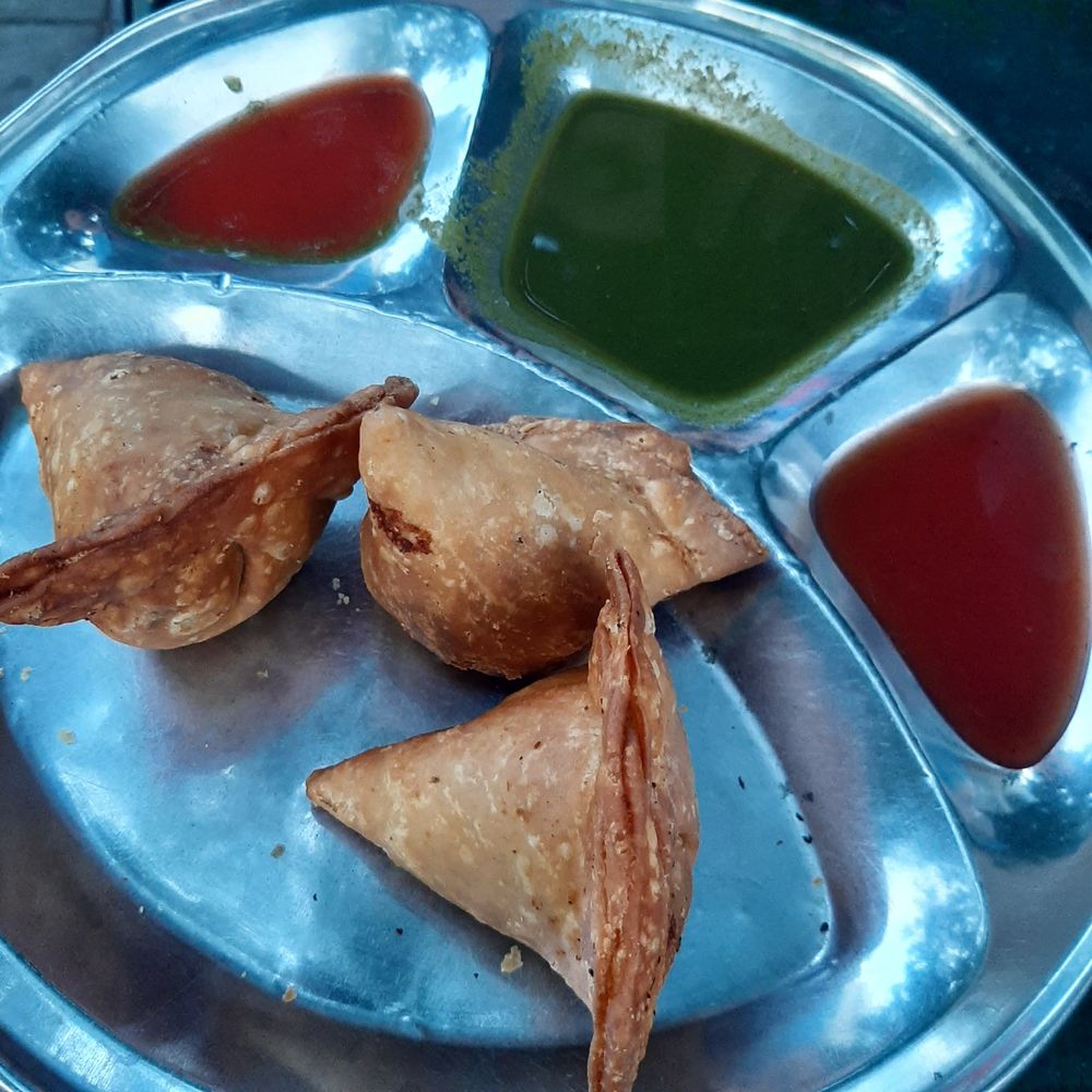 Golden fried samosas served with tamarind and mint chutneys